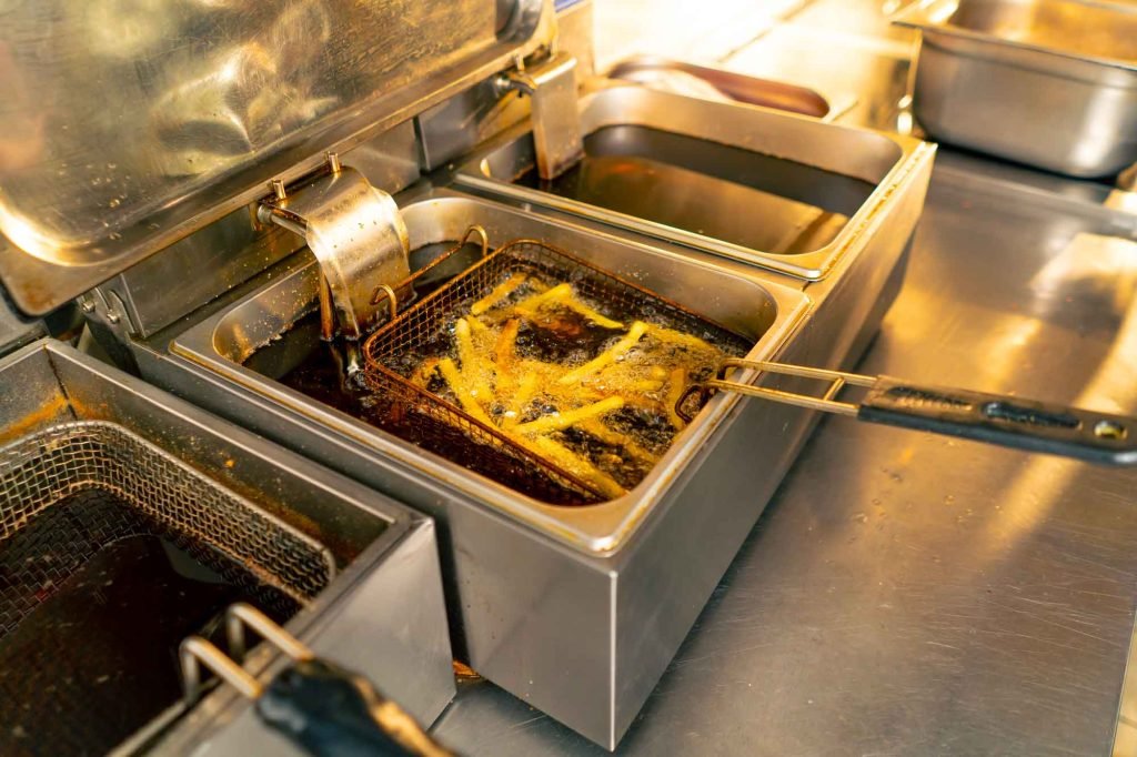 Friteuse professionnelle en action avec panier de frites dorées